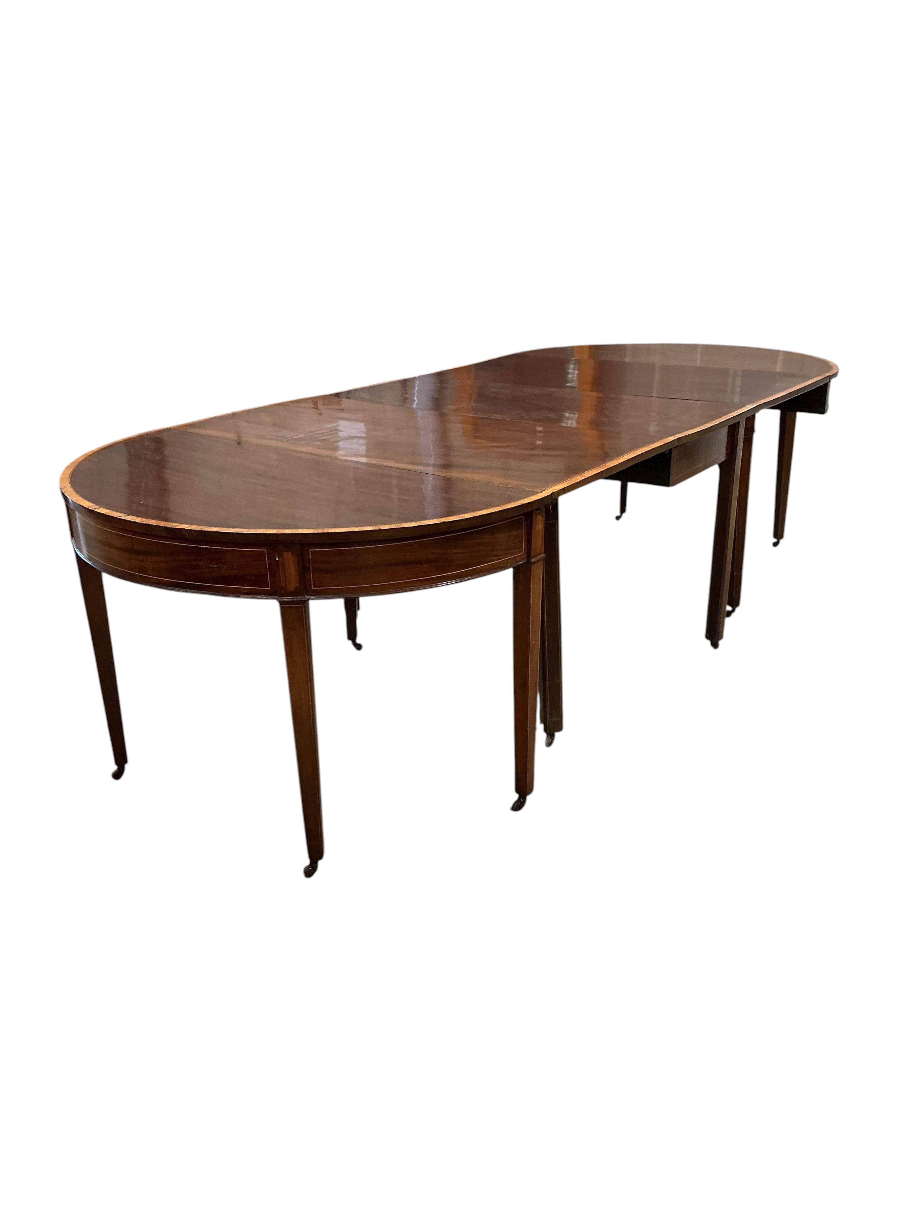 A George III satinwood banded mahogany D end extending dining table, with two spare leaves, 284cm extended, depth 120cm, height 74cm, together with a set of eight Victorian mahogany balloon back dining chairs